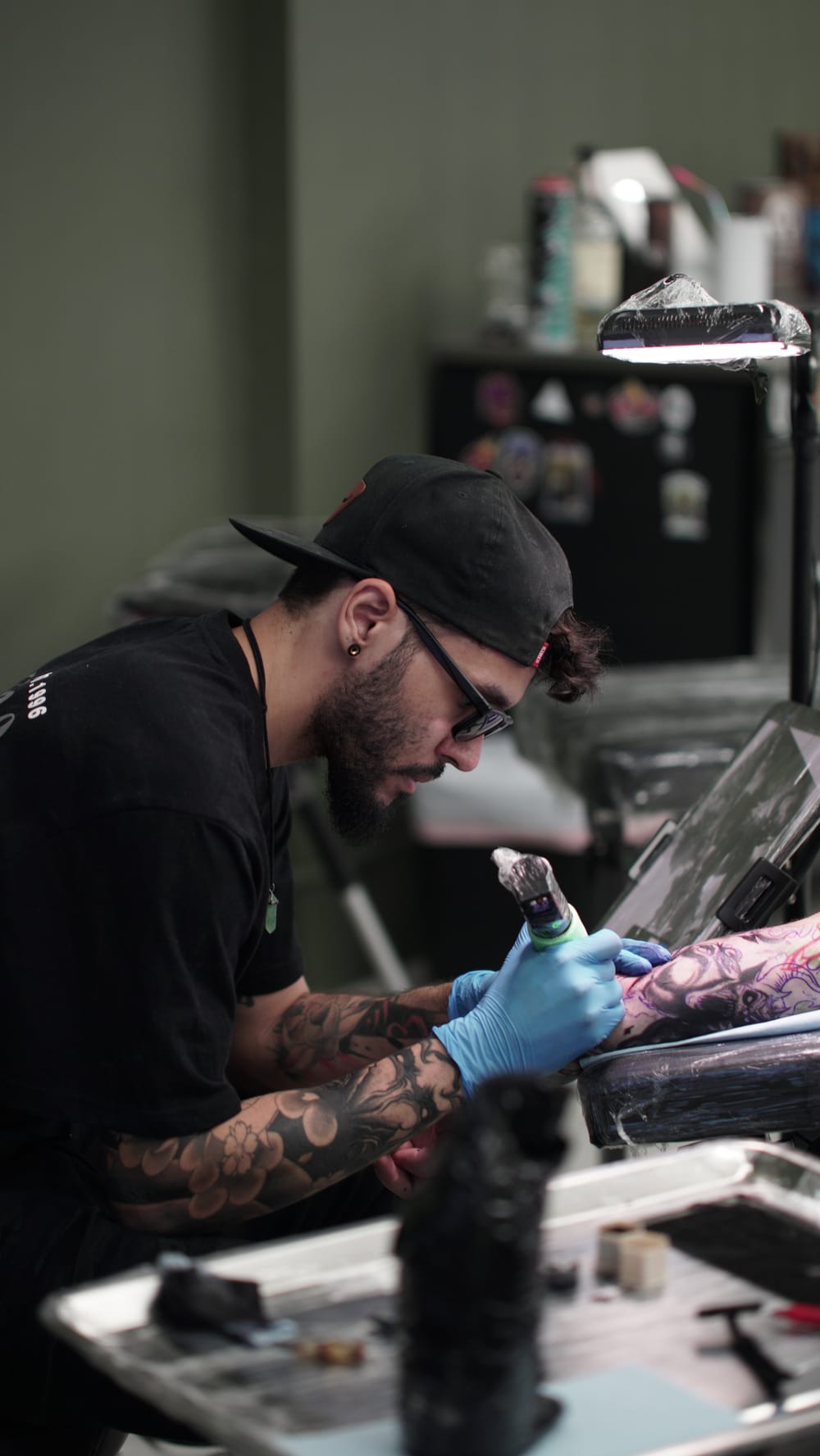 Tristan Towers tattooing a client while wearing gloves