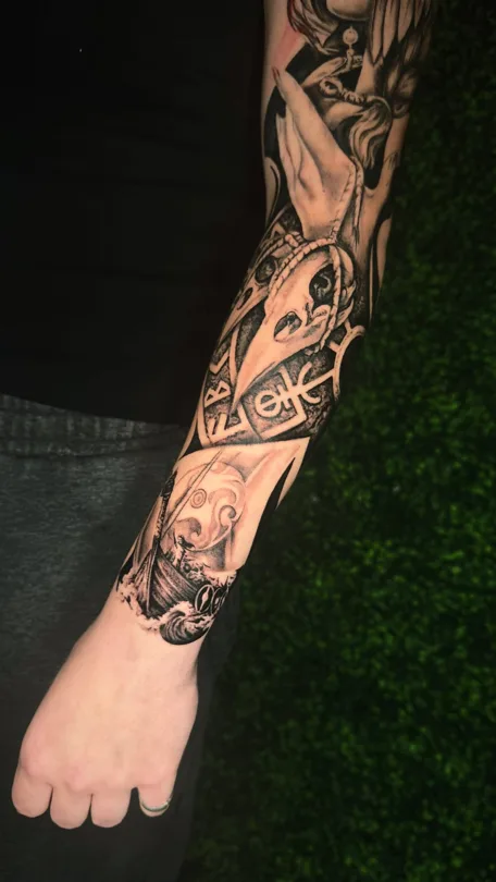 Tattoo of black and grey arm composition with geometric and ornamental detail